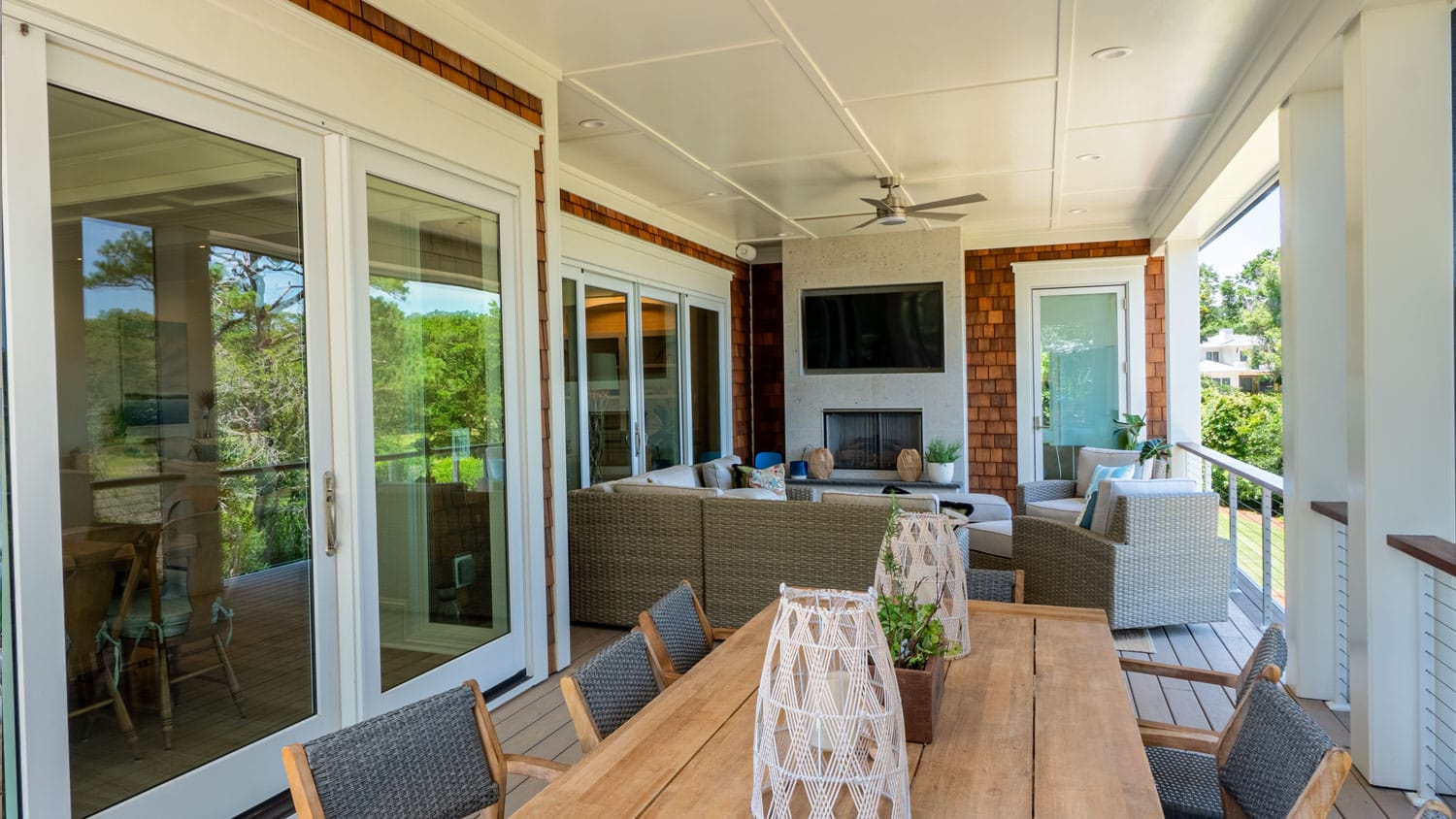 Photo of a coastal home and the wrap-around porch with entertainment and dining areas