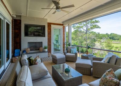 Photo of enhanced outdoor features with a porch fireplace and built-in television with ample sitting options for guests